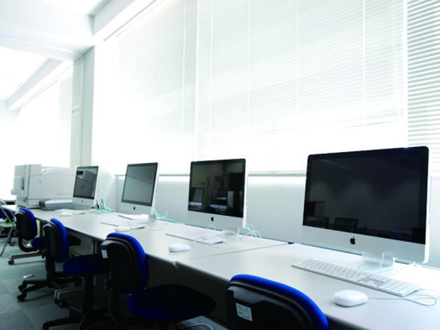 【コンピュータ室】（静岡瀬名キャンパス）造形学部でデザインを学ぶ学生が使用する教室です。最新のMacが100台以上設置されています。 