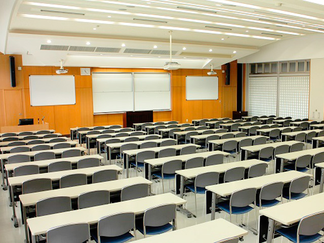 【大講義室】講義棟には講義室8室、演習室12室があり、OHCシステムやAVシステムを完備。大講義室には150名が会することが可能。