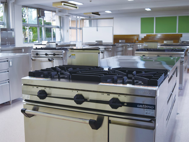 調理実習室101。プロ仕様の豪華なシステムキッチンが一堂に配置されています。