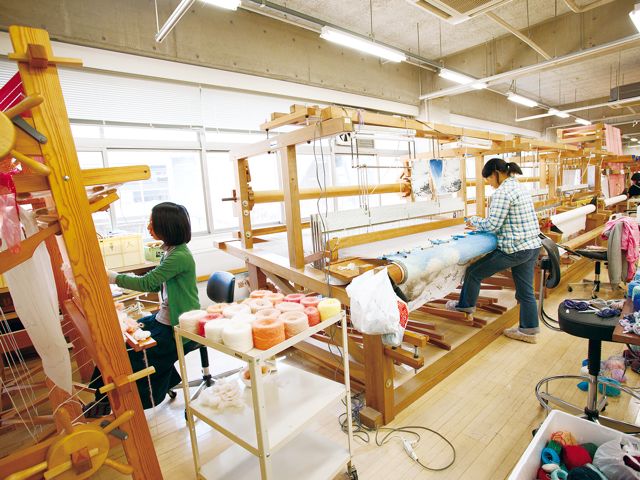 テキスタイル専攻染織工房：大小さまざまな織機が並び、 西陣織ができる織機から、 2m幅の大きな作品を織れるものまでさまざまな種類がそろっています。