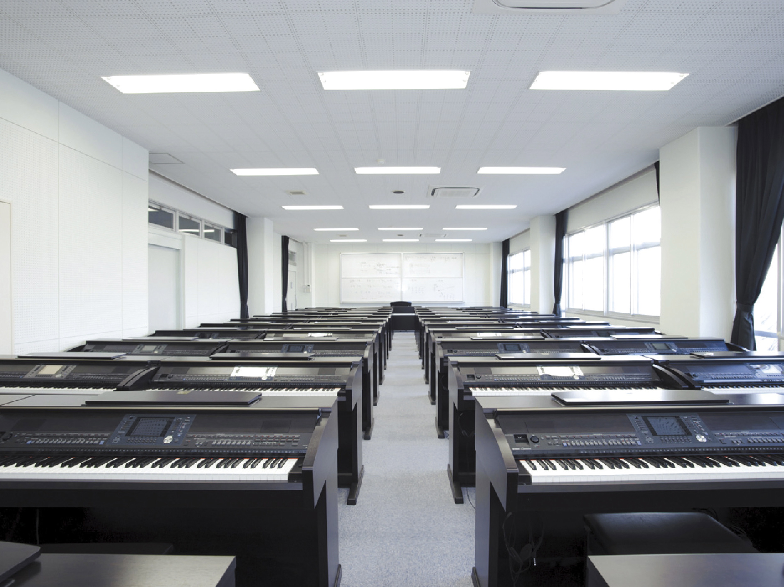 【都城キャンパス(1号館)】音楽室。電子ピアノ50台・アップライトピアノ10台を配置。授業だけでなく自主練習にも開放しています。