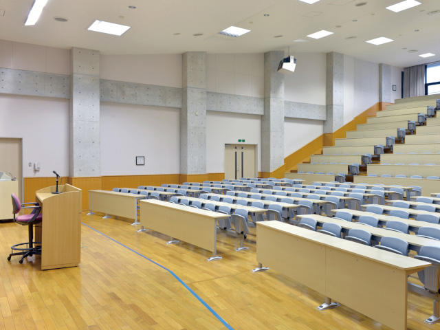 大講義室（笠間キャンパス）：300人を収容できる大講義室。温かみを感じさせる木目の床や自然光の差し込む開放的な造りとなっています