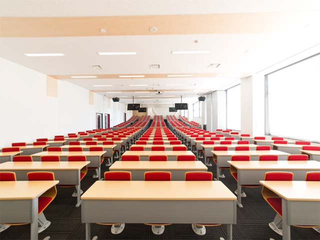 階段教室（テクノみらい館）。大人数の講義にも対応できる教室です。複数のモニターが設置され、後方の席でも安心して受講できます。