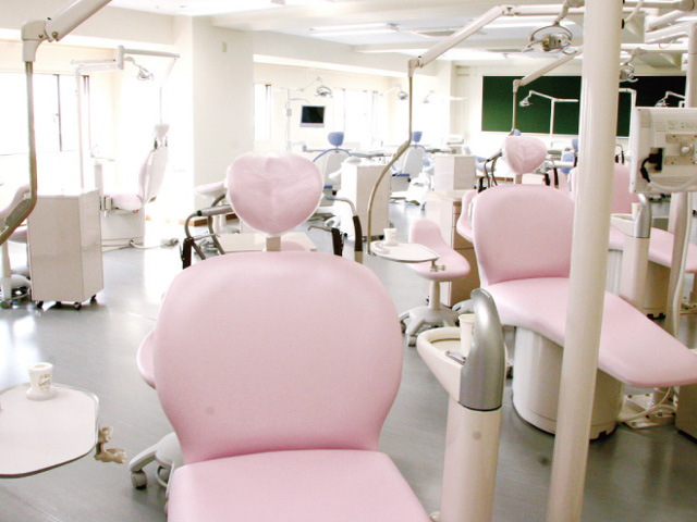 【基礎実習室】歯科医院と同じユニット（診療台）を16台完備し、3人で1台使用できます。